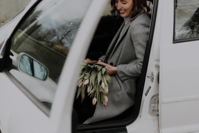 Woman in a car, holding flowers